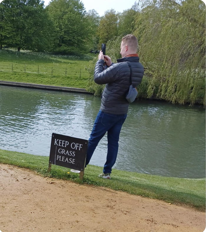 Sign says “keep off grass please” yet the tourist choose
